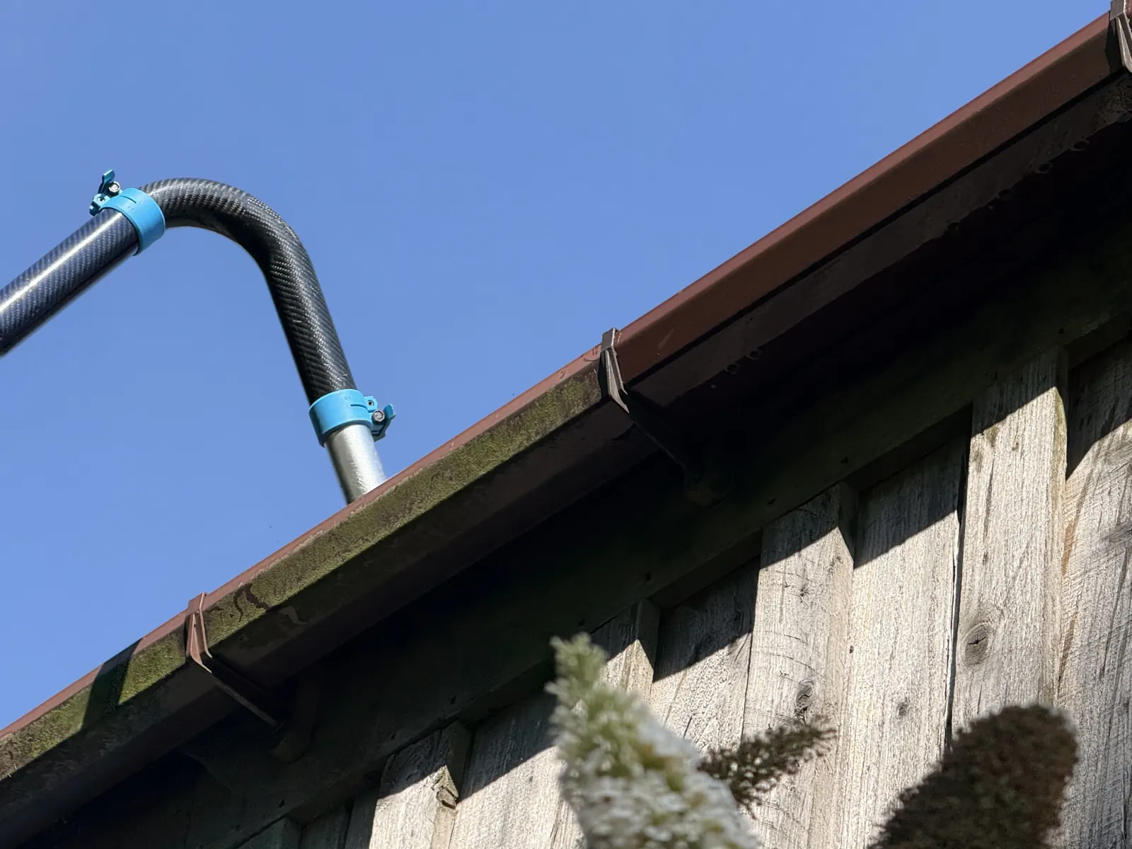 Close-up of a gutter vacuum nozzle at a roofline