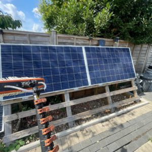 Solar panels with a cleaning brush beside a residential property