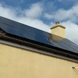 Solar panels and chimney on a rendered residential roof