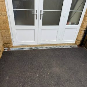 White glazed patio doors with a drainage channel
