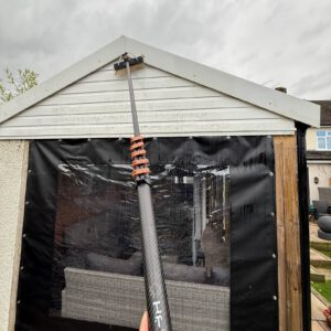 Window cleaning brush on white gable exterior