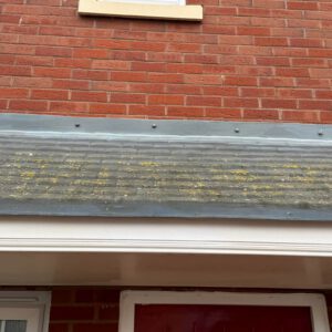 Brick exterior wall with a tiled roof edge and guttering