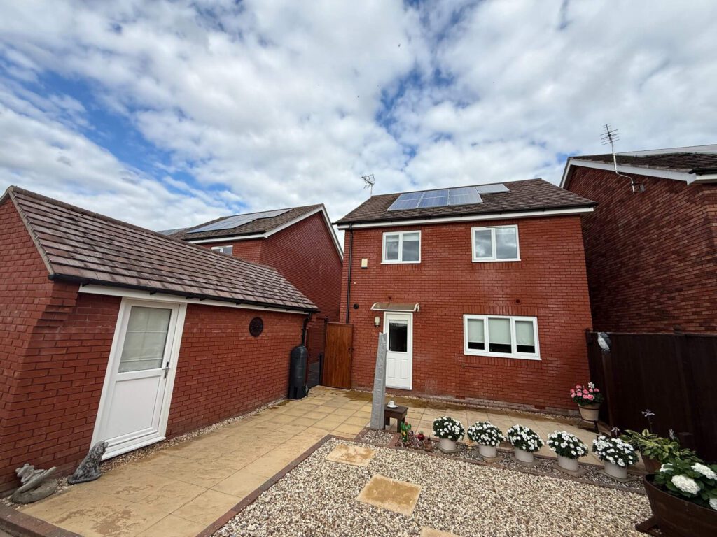 Exterior of a red-brick residential property in Uckington, Cheltenham, with tiled roofs and solar panels
