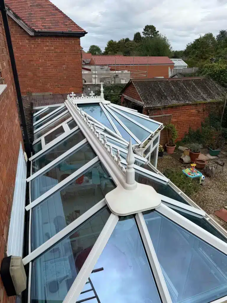 Wide view of the cleaned conservatory roof with white glazing bars and angled roof sections on Finlay Road